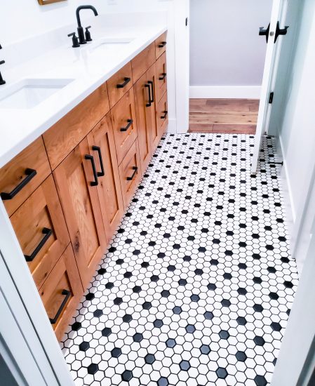 Black and white tiled floor with wooden cabinets